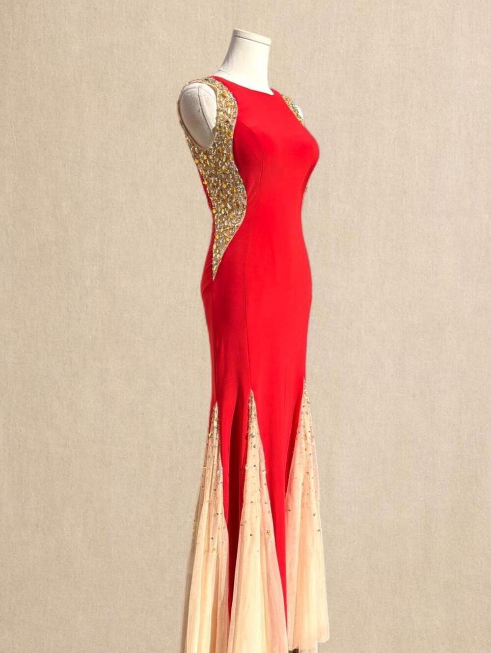 Red beaded mermaid gown with gold beading and sheer panels at the hem